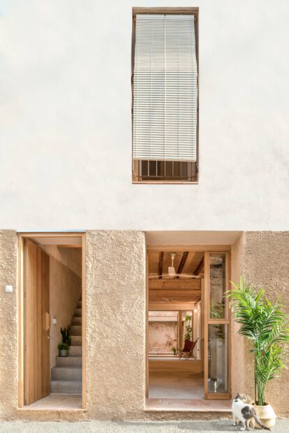 Detalle de fachada con revestimiento de cal en diferentes texturas de la entrada a las viviendas.