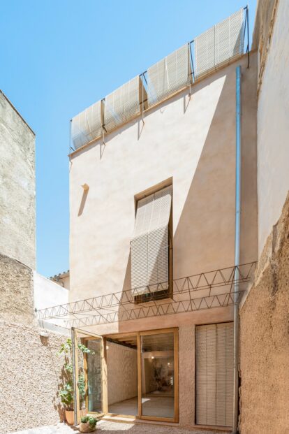 Fachada posterior con carpinterías de madera y conexión en planta baja con el patio.